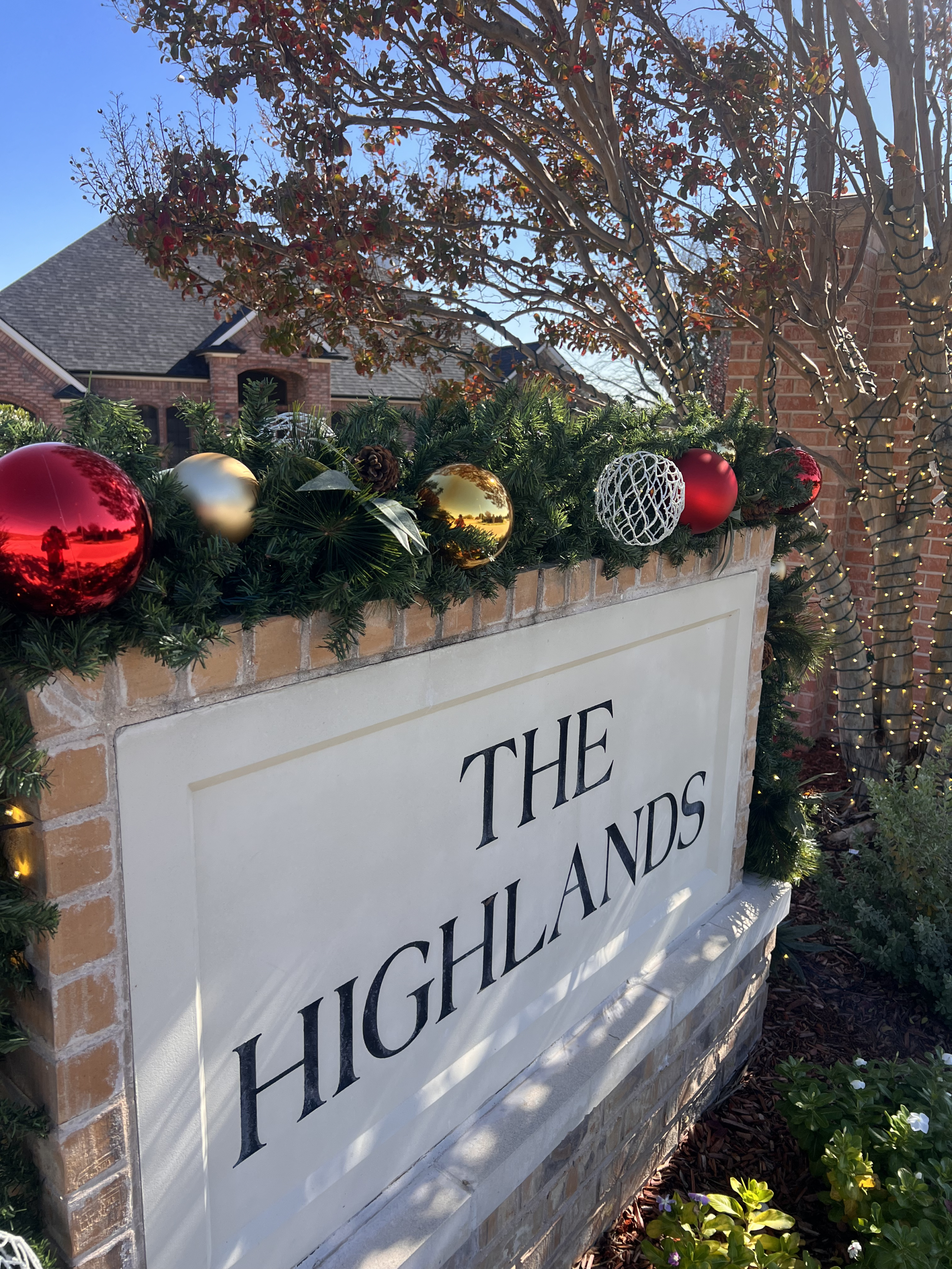 Christmas light installation for homeowners association featuring a Monument Sign With Holiday Decor By A Christmas Decorating Company