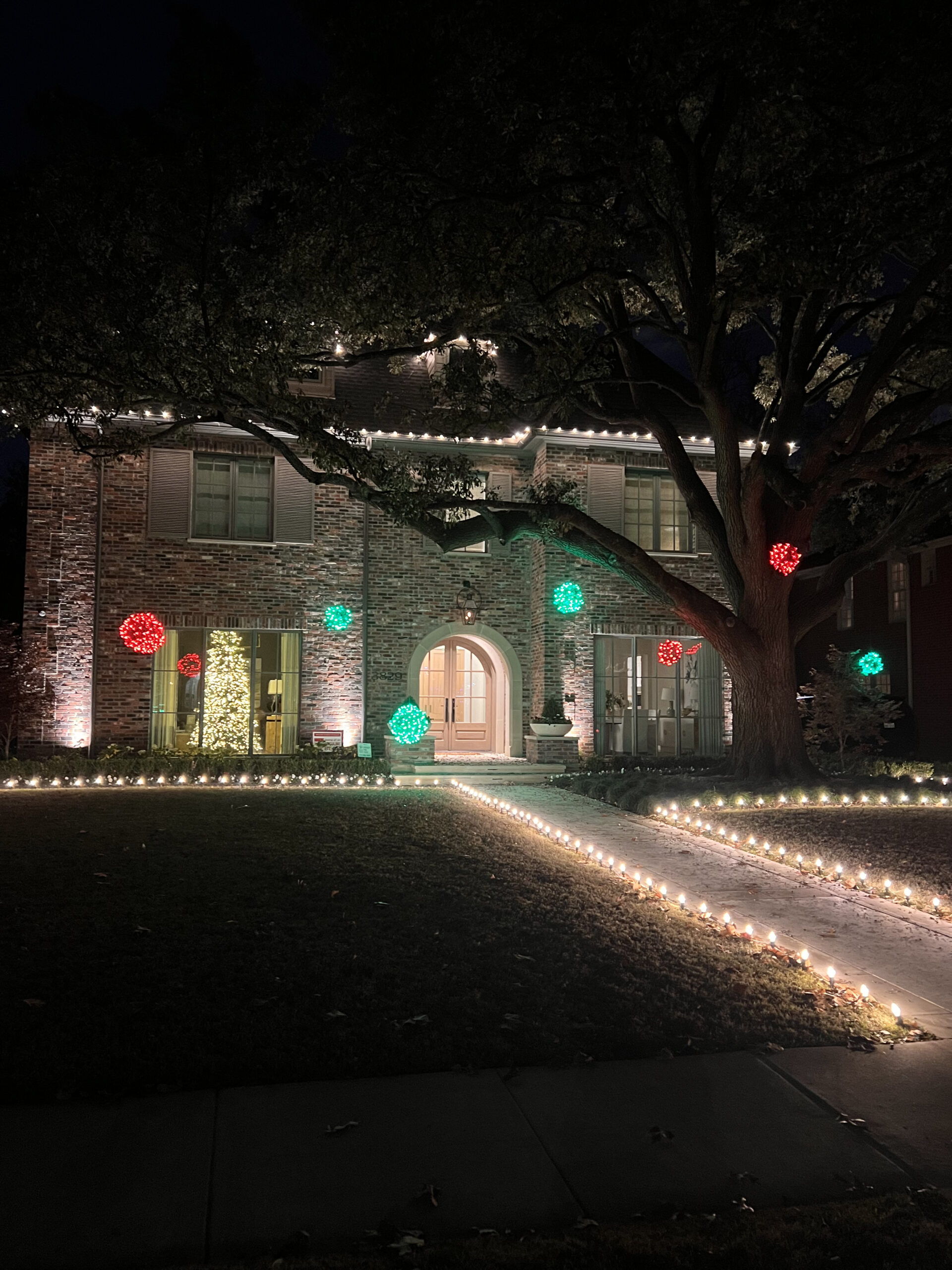 House near Highland Park decorated with custom Christmas light package featuring large wicker balls with lights.